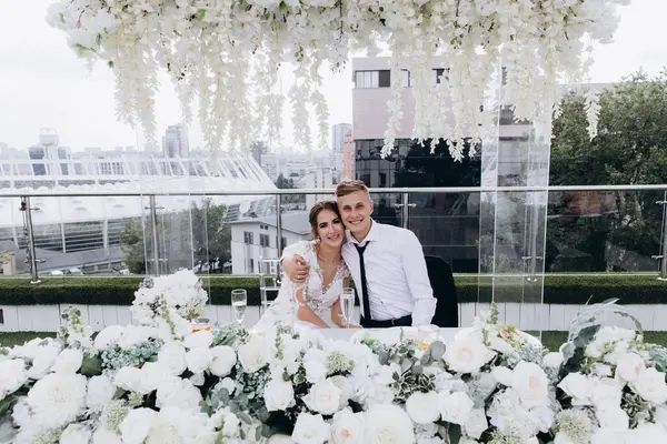 Gelin ve damat düğün masasında birlikte oturuyorlar.                    