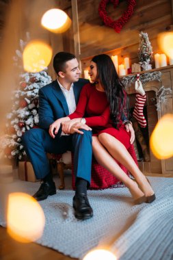 Şöminenin yanında birbirine aşık mutlu çift poz veriyor. 