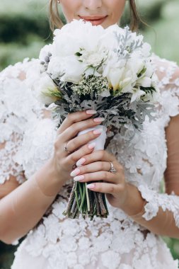 Beyaz elbiseli güzel gelin elinde düğün buketi                 