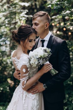 Güzel, mutlu, genç bir çift yeşil parkta birbirlerine poz veriyorlar.              