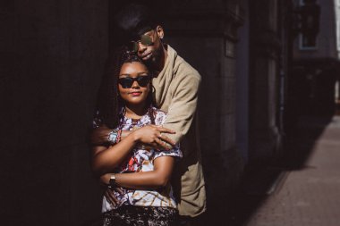 Genç, güzel siyah çift şehirde güneş gözlükleriyle poz veriyor.