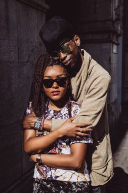 Genç, güzel siyah çift şehirde güneş gözlükleriyle poz veriyor.