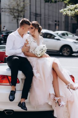 Şehirde lüks bir arabada oturan genç ve güzel bir çift. 