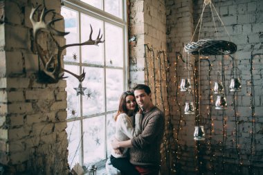 Güzel, mutlu, birbirine aşık genç bir çift sıcak bir odada kucaklaşıyorlar..                   