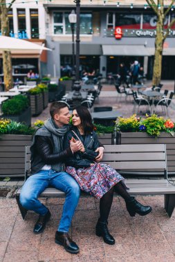 Güzel bir çift kenarda otururken poz veriyor. 