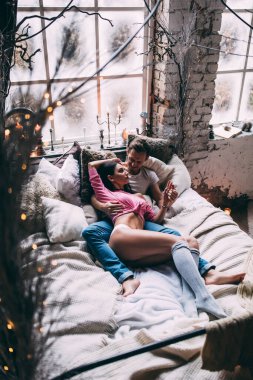 Yatakta genç ve güzel bir çiftin stüdyo fotoğrafı.