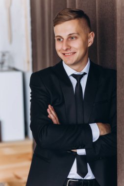 Takım elbiseli yakışıklı bir adamın portresi gülümsüyor ve yana bakıyor.