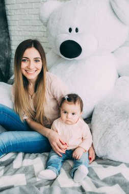 Anne ve tatlı kızı yatakta oturuyor. 