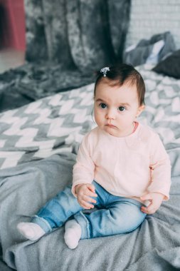Küçük bir kız bebek yatak odasında bir yatakta