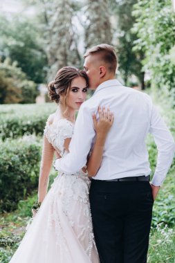 Güzel, mutlu, genç bir çift yeşil parkta birbirlerine poz veriyorlar.              