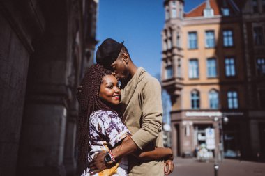 Mutlu, genç, Afro-Amerikan çift şehir caddesinde birlikte yürüyor.