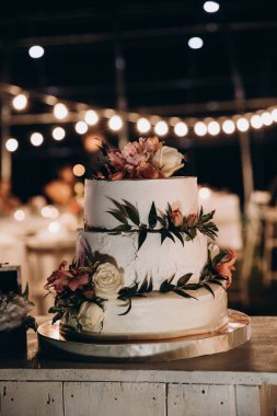 Masanın üzerinde çiçekler olan güzel bir pasta. Çiçekli düğün pastası        