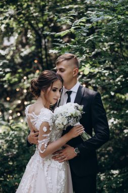 Güzel, mutlu, genç bir çift yeşil parkta birbirlerine poz veriyorlar.              