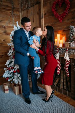 Noel süslemeli stüdyodaki genç aile fotoşizasyon yaşıyor. 