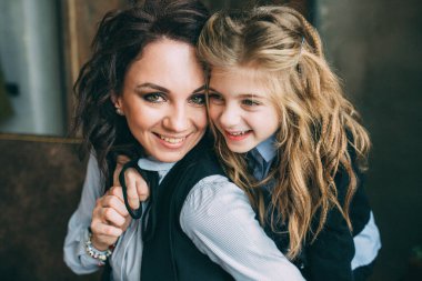 Anne ve kızı stüdyoda Noel ağacıyla poz veriyorlar.