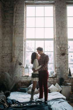 Güzel, mutlu, birbirine aşık genç bir çift sıcak bir odada kucaklaşıyorlar..                   