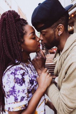 Afrikalı çift sokakta öpüşüyor ve sarılıyor.