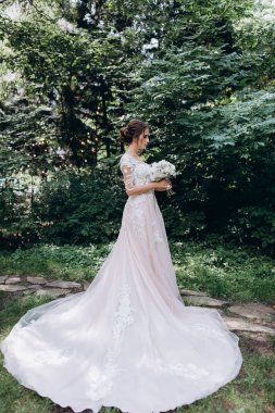 Beyaz elbiseli güzel gelin elinde düğün buketi                 