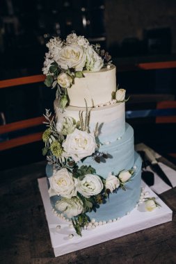 Masanın üzerinde çiçekler olan güzel bir pasta. Çiçekli düğün pastası        