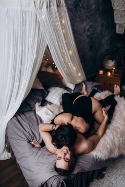 Mutlu genç çift evde yatakta yatıyor.