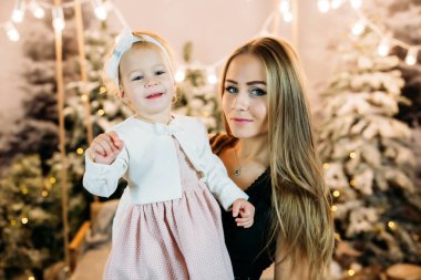 Anne ve kızının yeni yıl arkaplanda bir noel ağacı var.