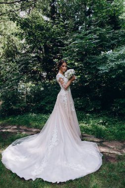 Beyaz elbiseli güzel gelin elinde düğün buketi                 