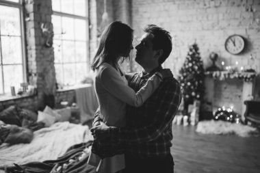 siyah ve beyaz, mutlu genç bir çiftin evde kucaklaşmasının görüntüsü.