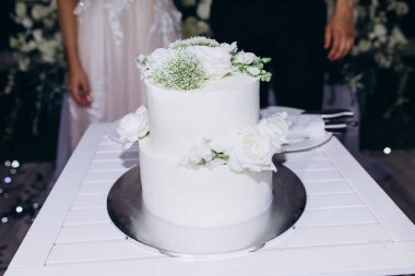 Gelin ve damat çiçeklerle süslenmiş lezzetli düğün pastalarıyla