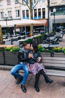 Güzel bir çift kenarda otururken poz veriyor. 