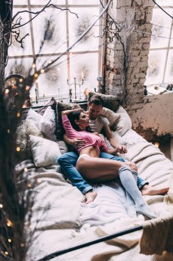 Genç, güzel bir kadın ve yakışıklı bir adam stüdyoda yatakta yatıyor. 