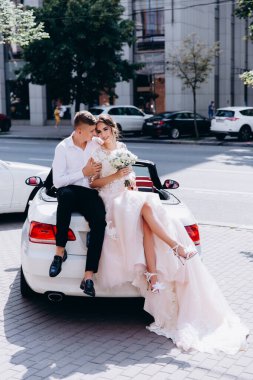 Şehirde lüks bir arabada oturan genç ve güzel bir çift. 