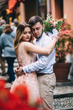 Güzel, mutlu bir düğün çifti. Eski kasabada sokakta sarılıyorlar..