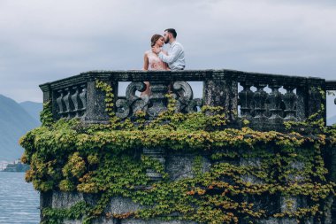 Genç romantik çift dağ gölü yakınlarındaki eski kulenin tepesinde.