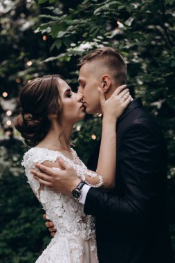 Güzel, mutlu, genç bir çift yeşil parkta birbirlerine poz veriyorlar.              