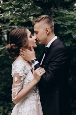 Güzel, mutlu, genç bir çift yeşil parkta birbirlerine poz veriyorlar.              