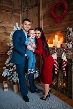 Noel süslemeli stüdyodaki genç aile fotoşizasyon yaşıyor. 