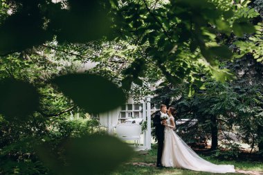 Güzel, mutlu, genç bir çift yeşil parkta birbirlerine poz veriyorlar.              