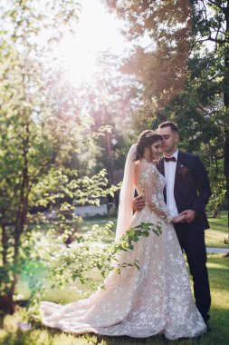 Mutlu çift yeşil bir parkta yürüyor ve gülümsüyor.