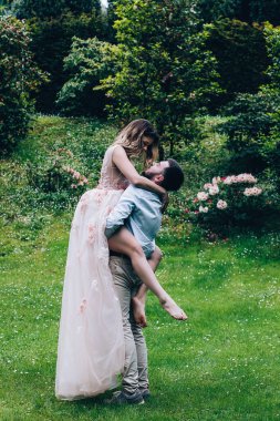 Güzel mutlu gelin ve damat parkta sarılıyor.  