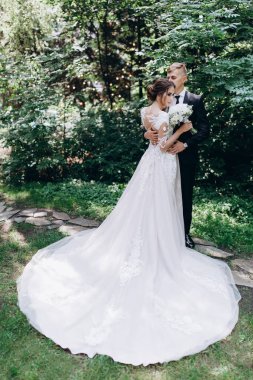 Güzel, mutlu, genç bir çift yeşil parkta birbirlerine poz veriyorlar.              