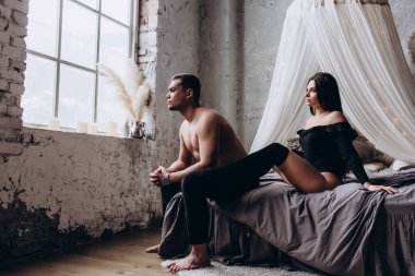Genç ve seksi bir çift yatakta poz veriyor..