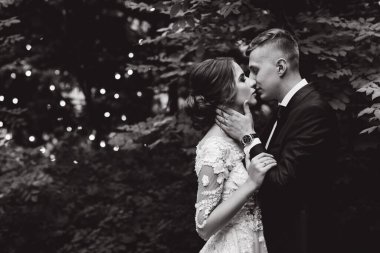 Güzel bir çift düğün günü dışarıda öpüşüyor, siyah beyaz.