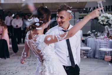 Genç mutlu çift dans ediyor ve birbirlerine bakıyorlar.