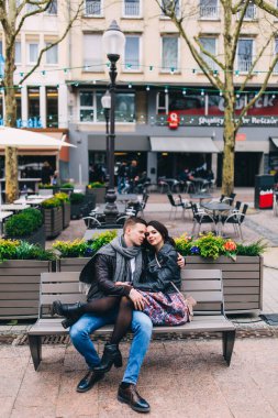 Aşık mutlu çift şehir caddesinde bankta oturuyor. 