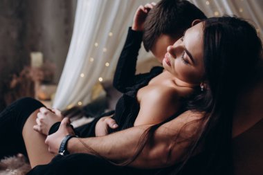 Genç ve seksi bir çift yatakta poz veriyor..