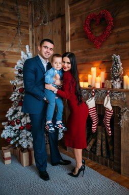 Noel süslemeli stüdyodaki genç aile fotoşizasyon yaşıyor. 