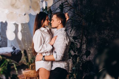 Güzel genç çift içeride sarılıp öpüşüyor.  