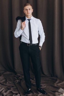 Stüdyoda poz veren yakışıklı damadın portresi.      