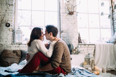 Güzel, mutlu, birbirine aşık genç bir çift sıcak bir odada kucaklaşıyorlar..                   