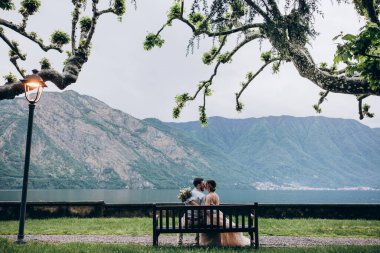 Dağ Gölü kıyısındaki bankta oturan çiftin arka görüntüsü.